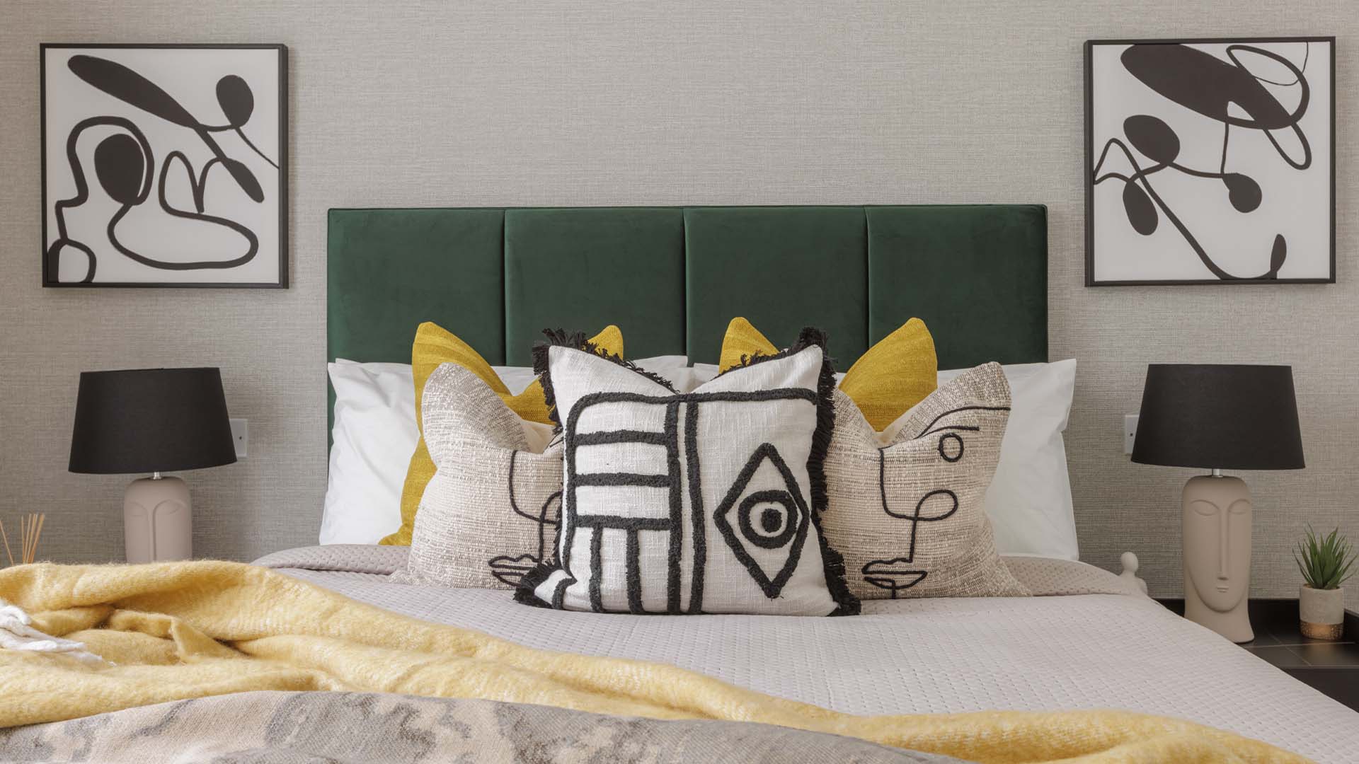 Bedroom with white and yellow pillows and artwork of Harcourt Gardens