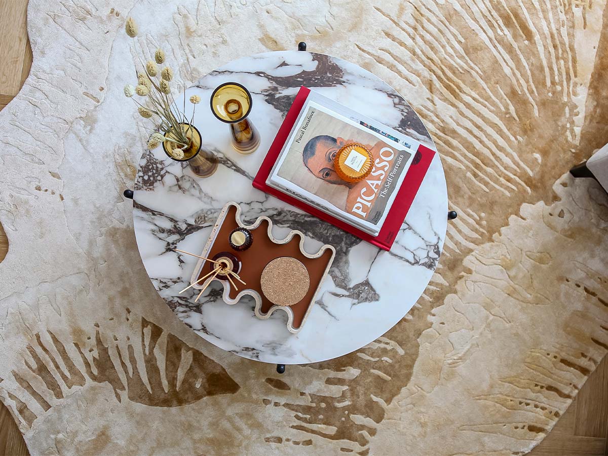 Marble coffee table with book, candles, and decor of 9 Milbank
