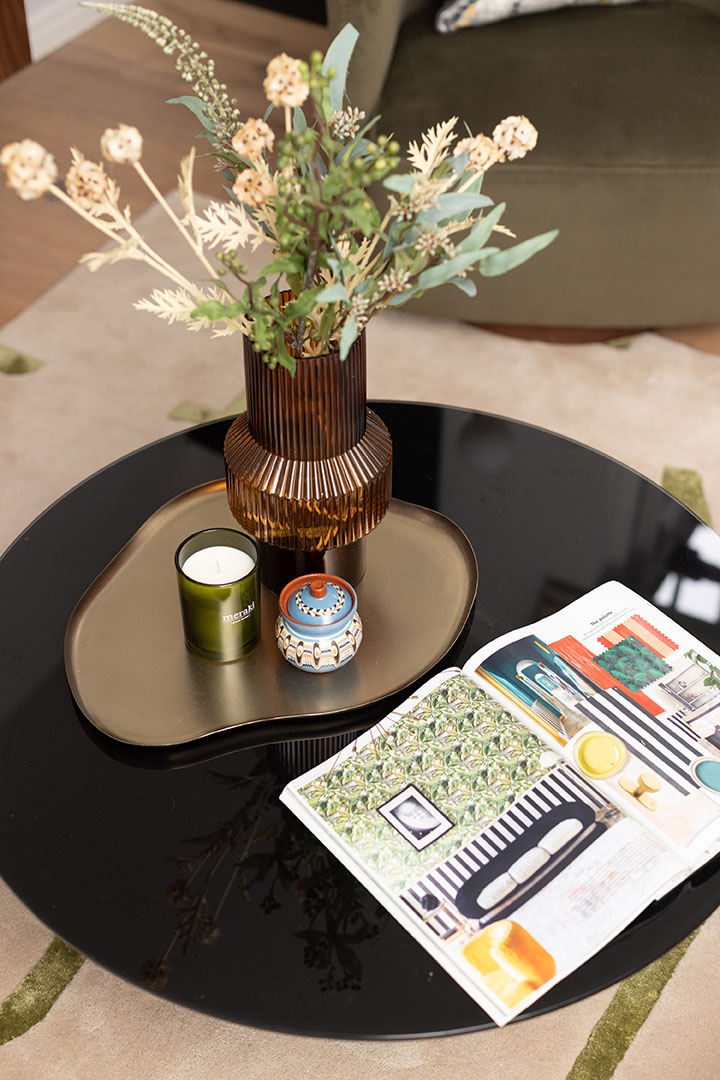 Coffee table decor with a vase, candle, and a magazine