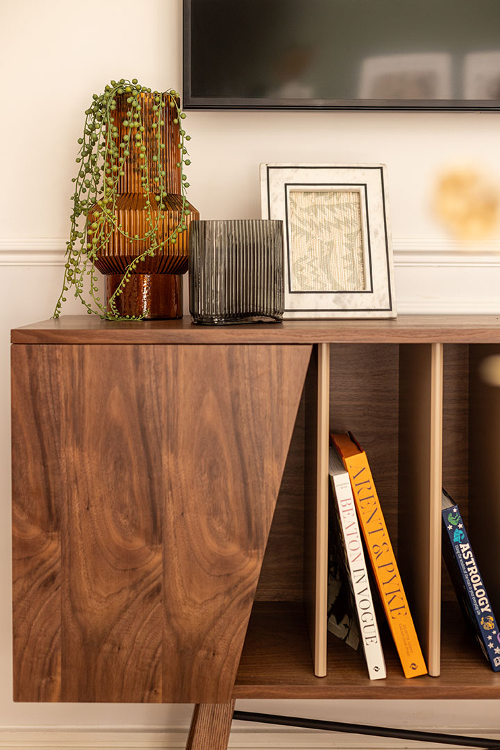 Modern TV stand with decorative vases, a frame, and books