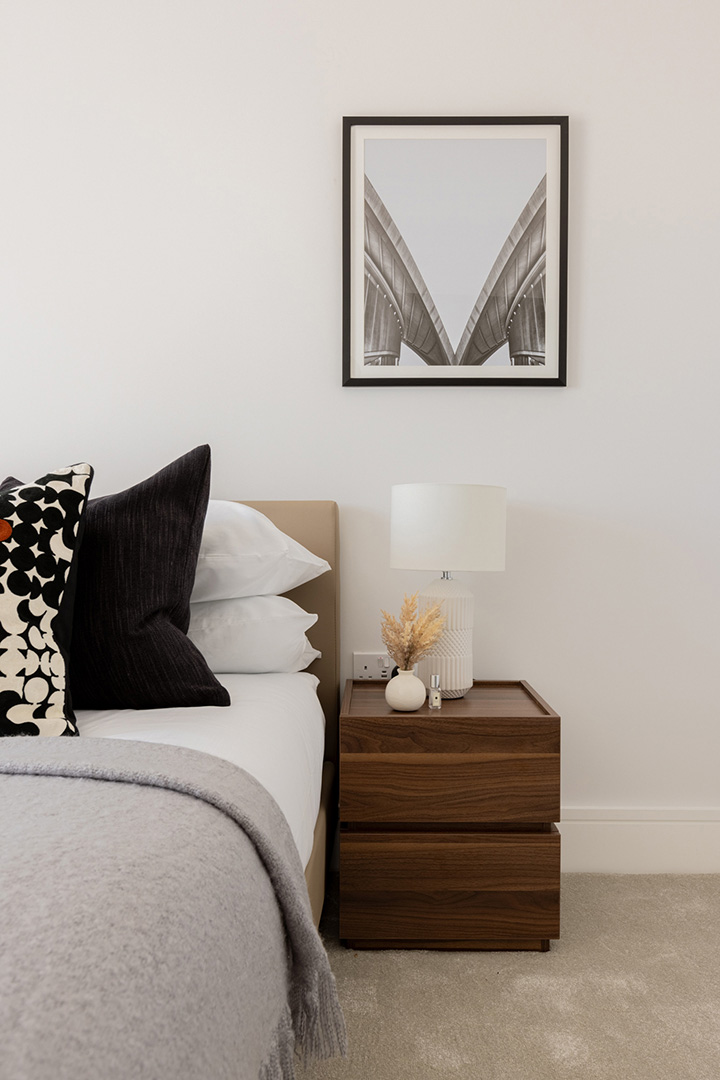 Modern bedroom with a framed photo, a lamp, and a nightstand