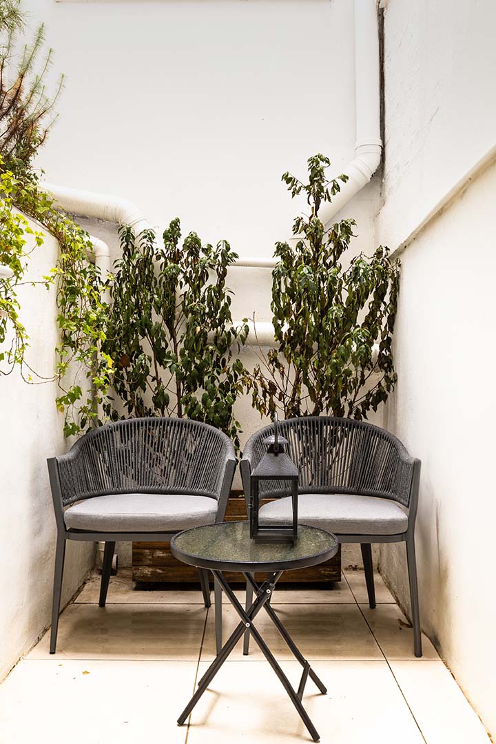 mall patio with greenery, two chairs, and a lantern