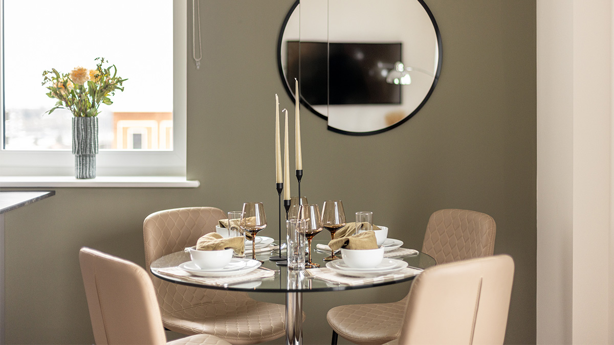 Round glass table with beige chairs at Pintail Heights