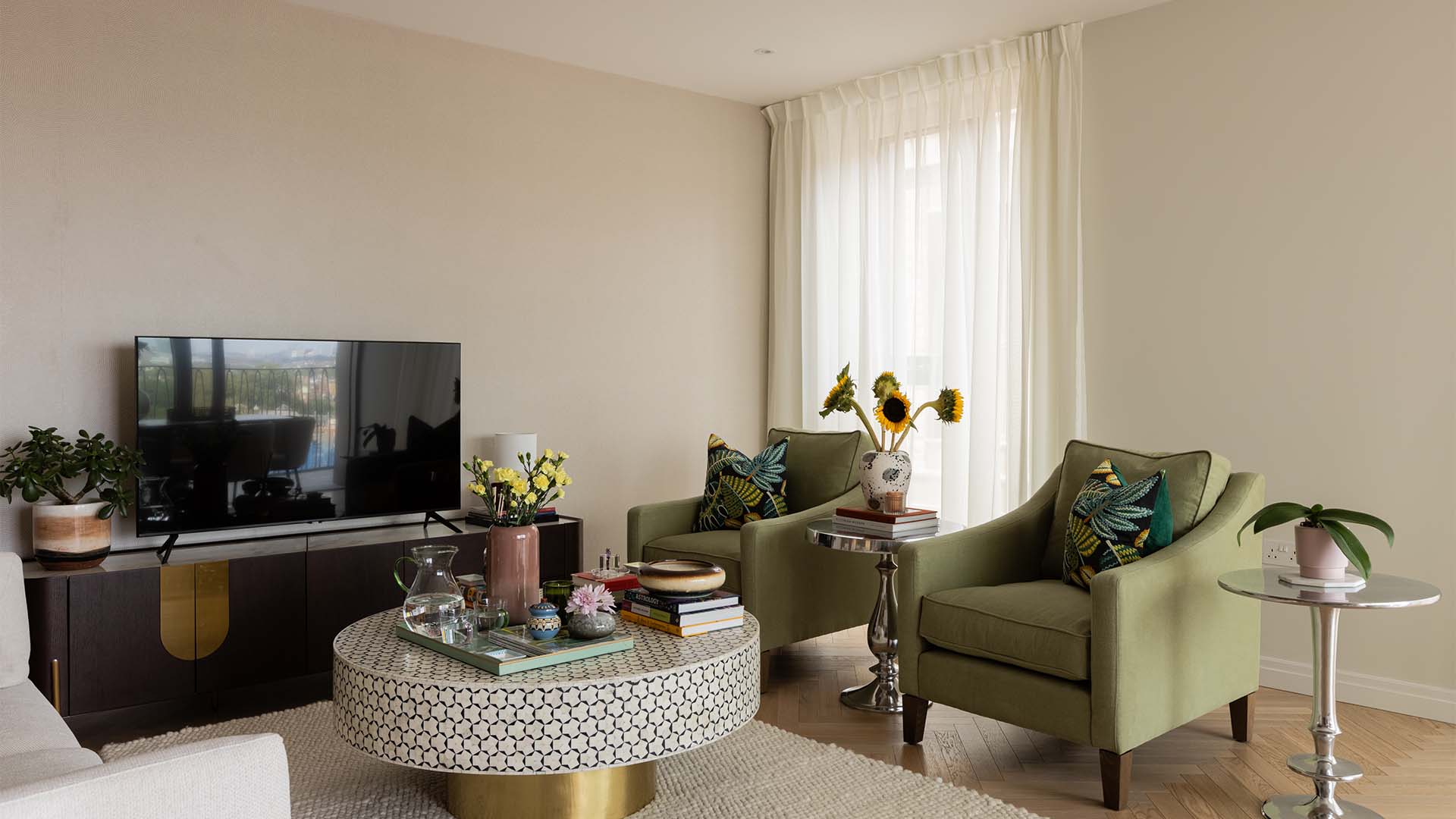 Living room with TV, armchairs, and side tables at Saxon House-45