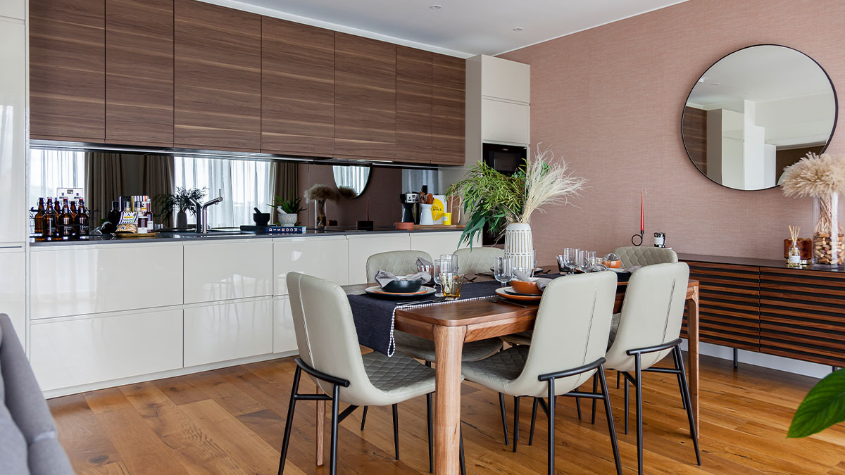 Modern kitchen and dining area with wood cabinets and a statement mirror