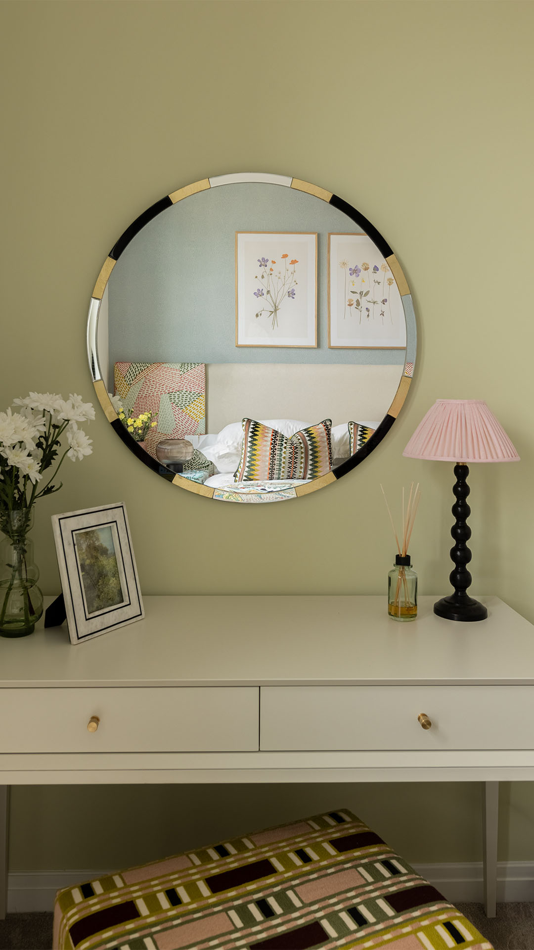 Oval mirror reflecting a bed in a bedroom at Saxon House-34