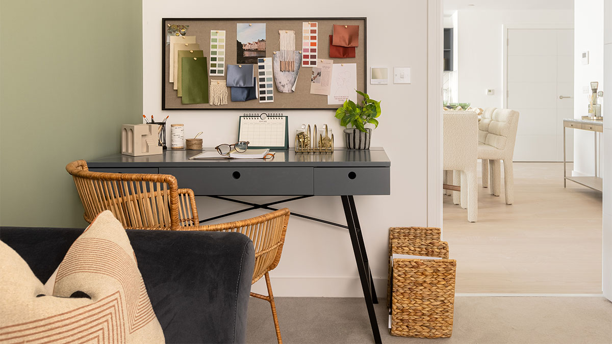 Grey desk with wicker chair, inspiration board, plant