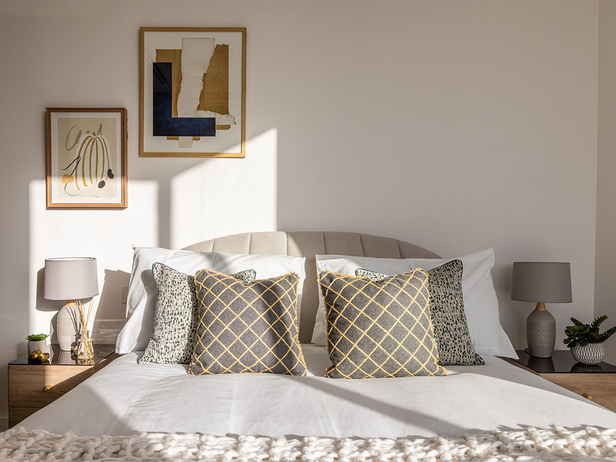 Styled bed with art and decorative pillows