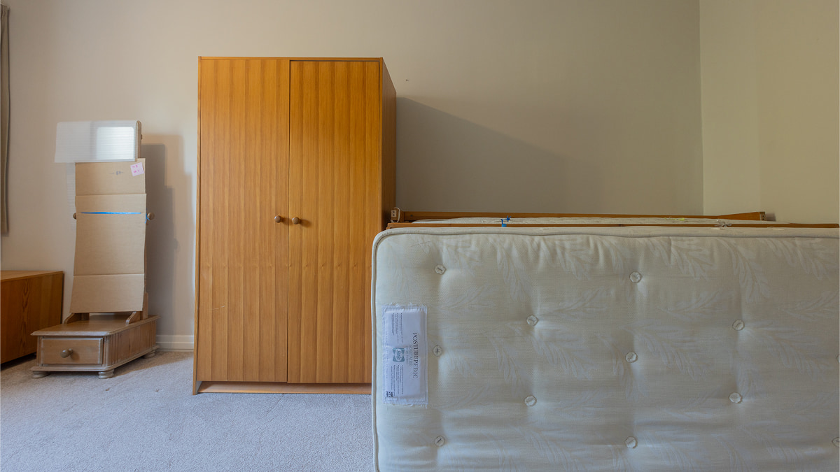 Bedroom before renovation with mattress and wardrobe