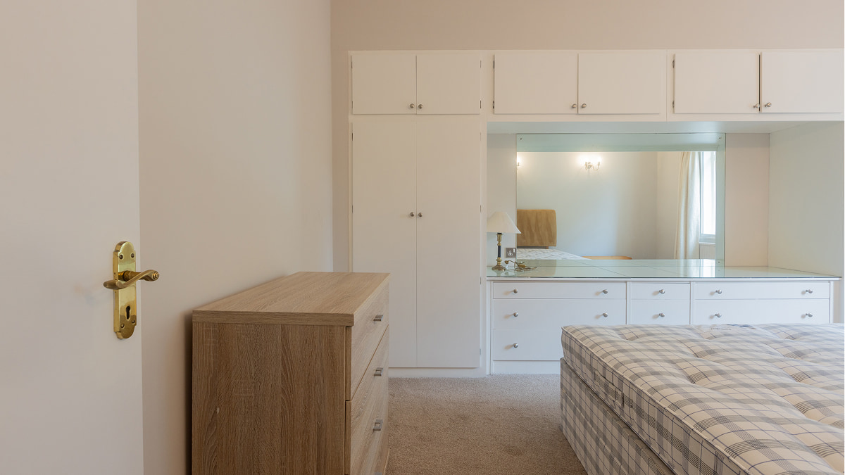 Room before staging with built-in wardrobes and chest of drawers