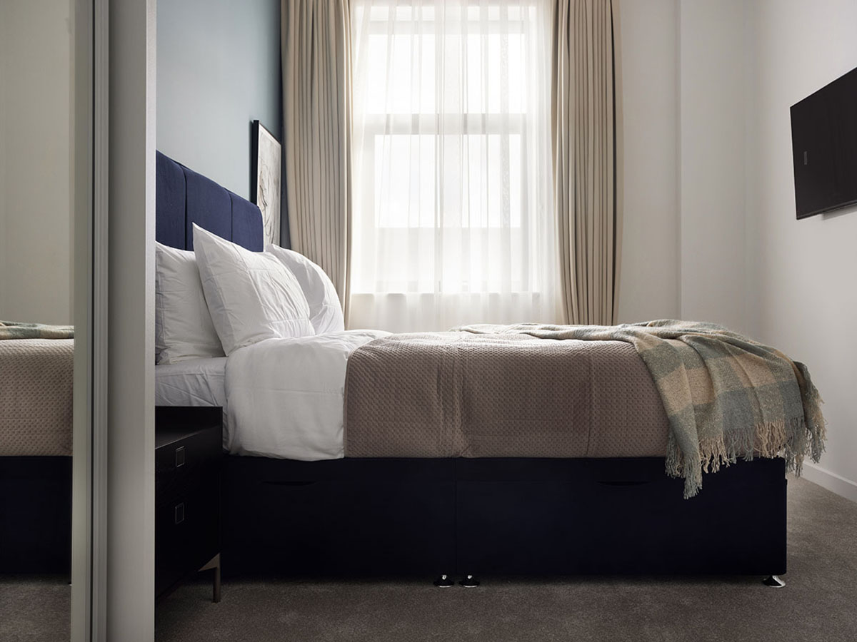 Small bedroom with window and sheer curtains