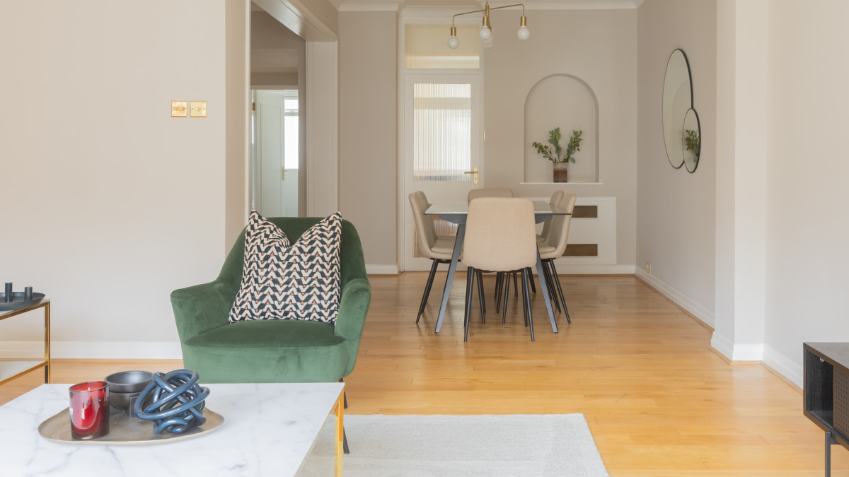 Furnished living area with green chair, dining set background