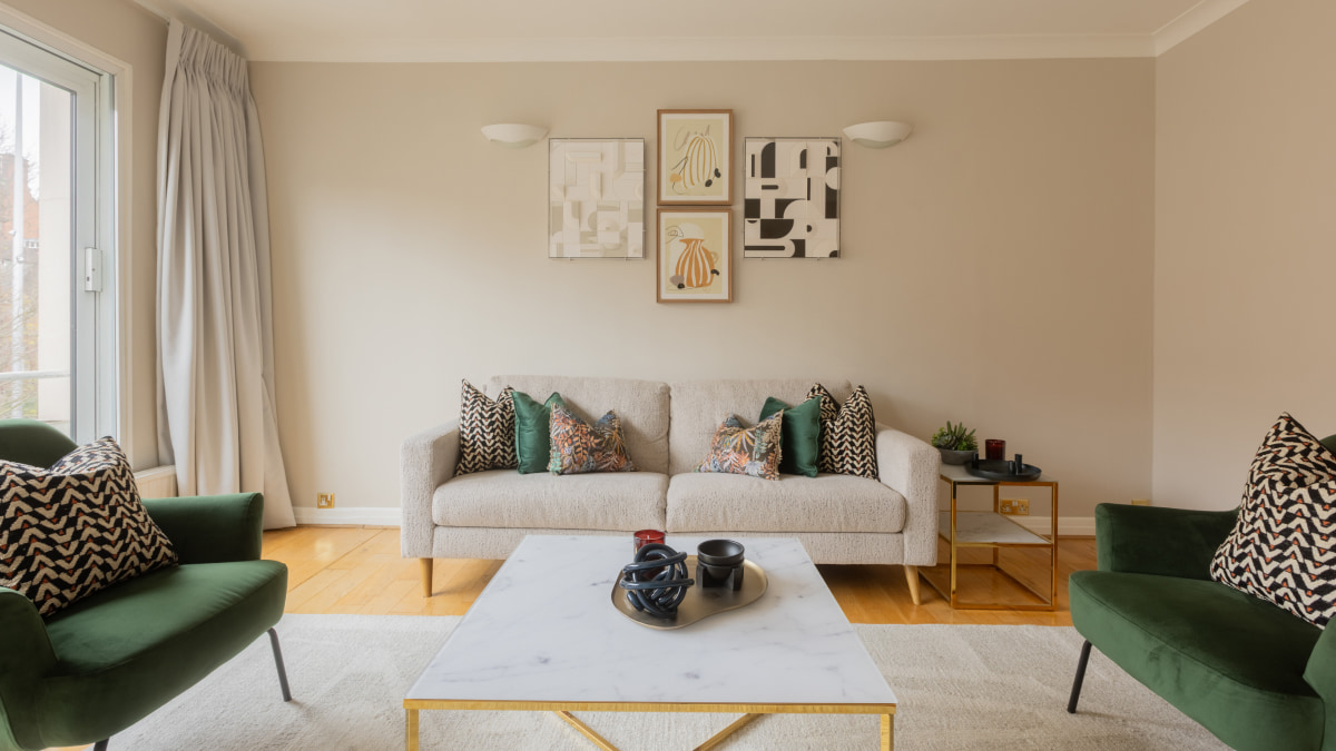 After Staged living room with sofa, green armchairs, and gallery wall