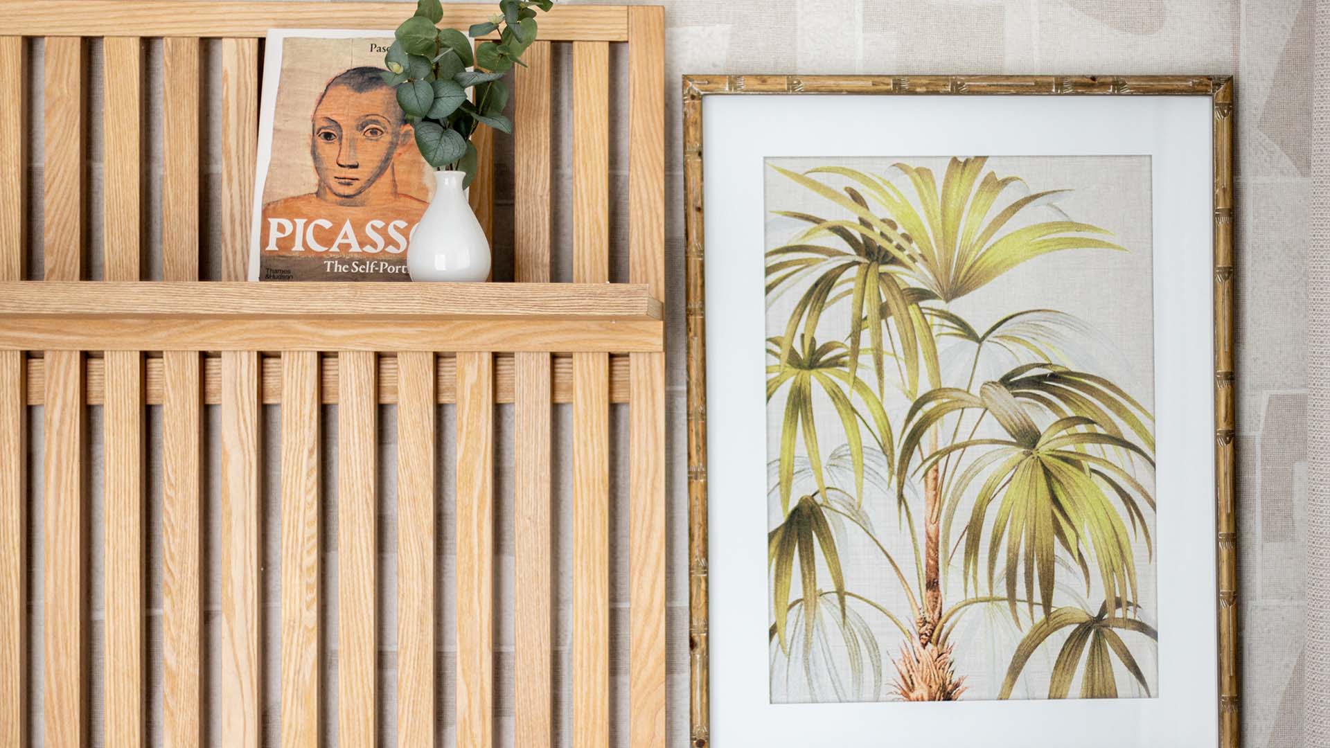 Art and plant on wooden headboard shelf at Fulton & Fifth