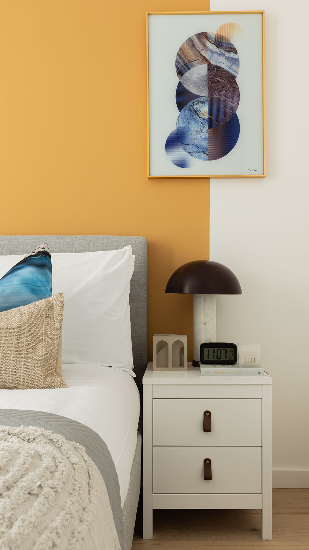 Bedroom with white nightstand and art