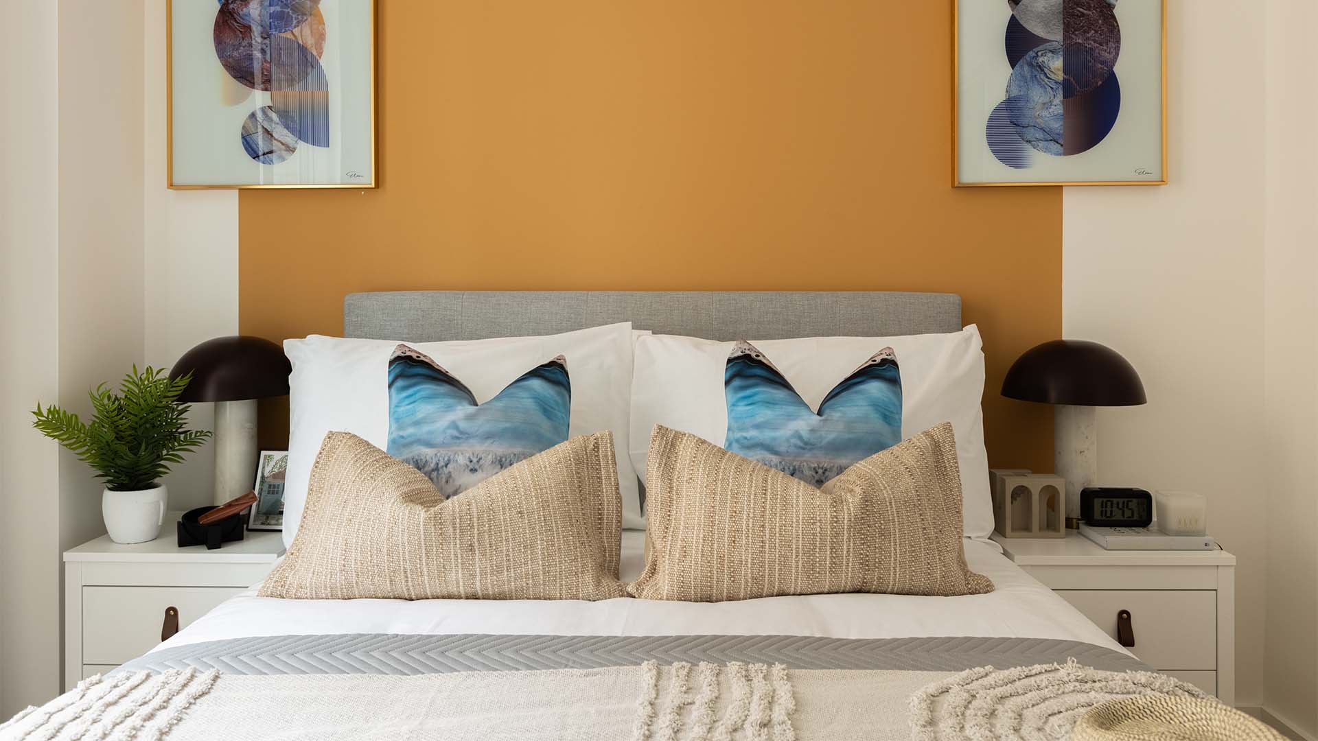 Decorated bed with plant and framed art