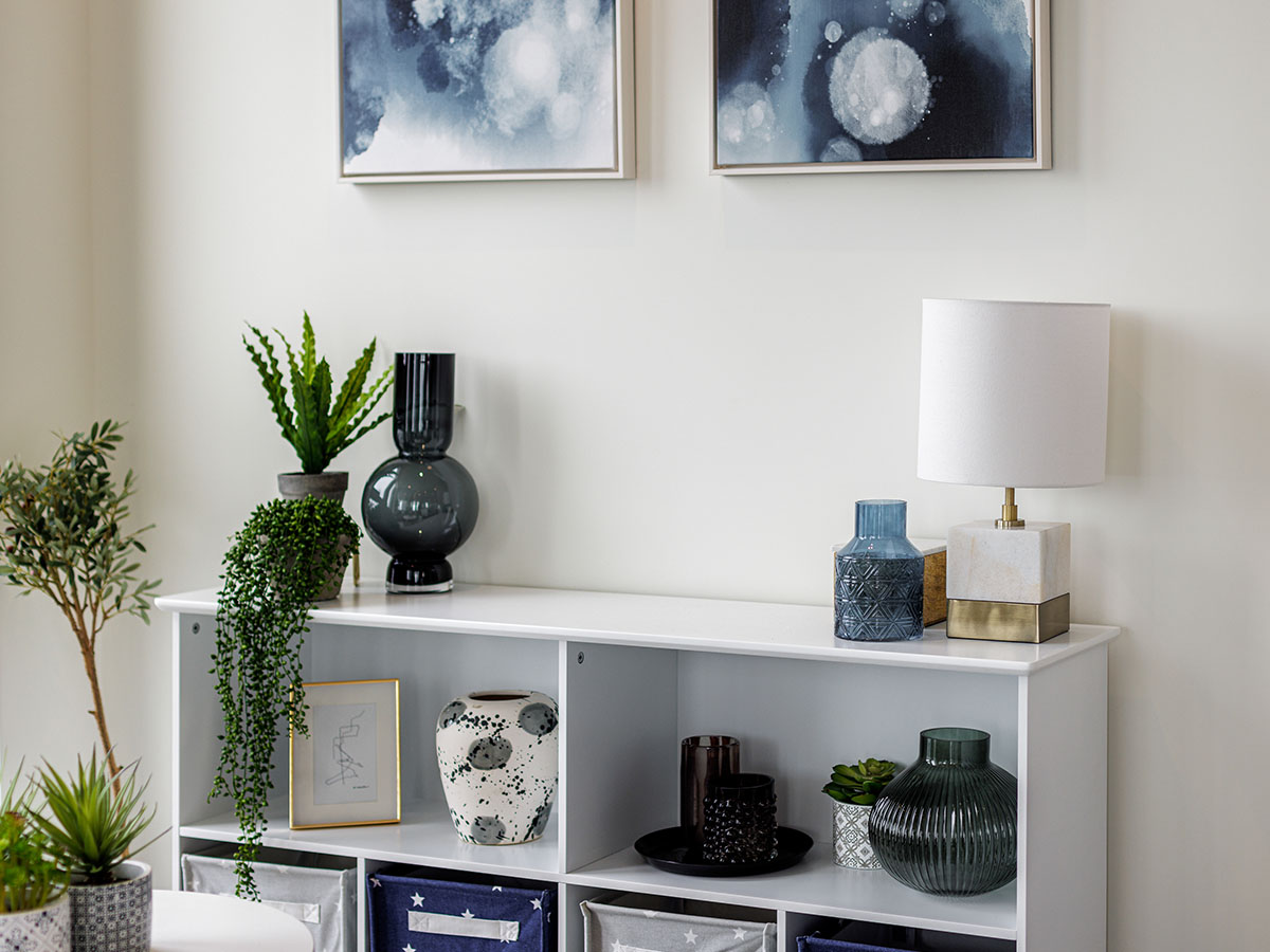 Triptych Bankside shelf with ceramic vases, plants, and a table lamp