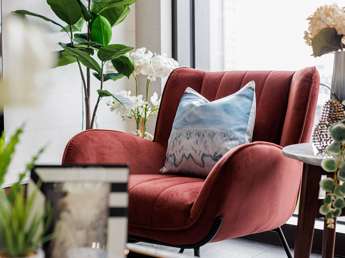 Triptych Bankside red velvet armchair with blue patterned throw cushion