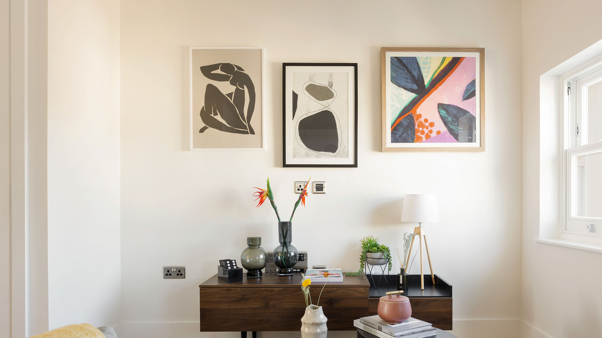 Stylish console table with vases and abstract wall art