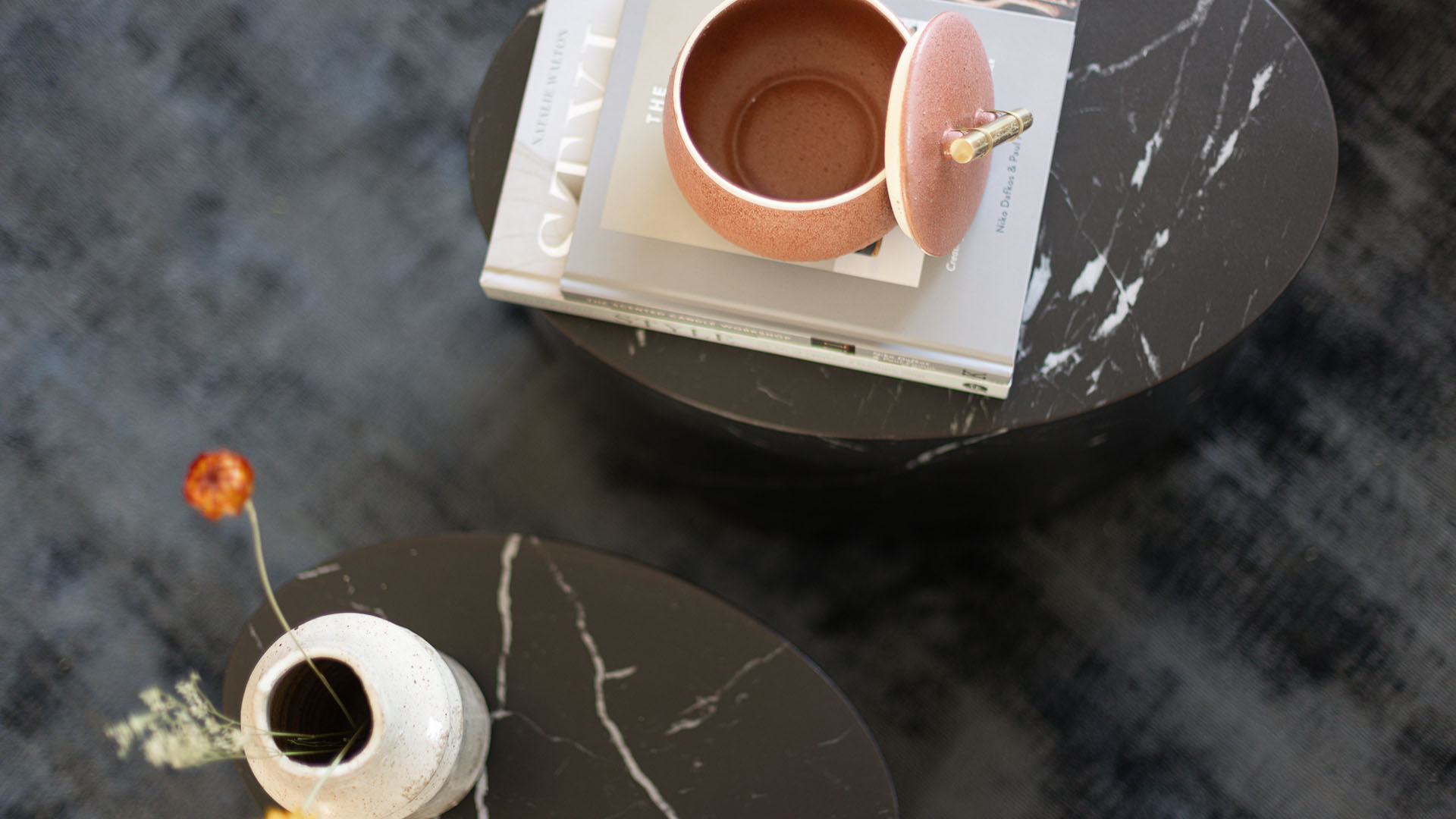 Black marble coffee tables with vase and books in stylish living room