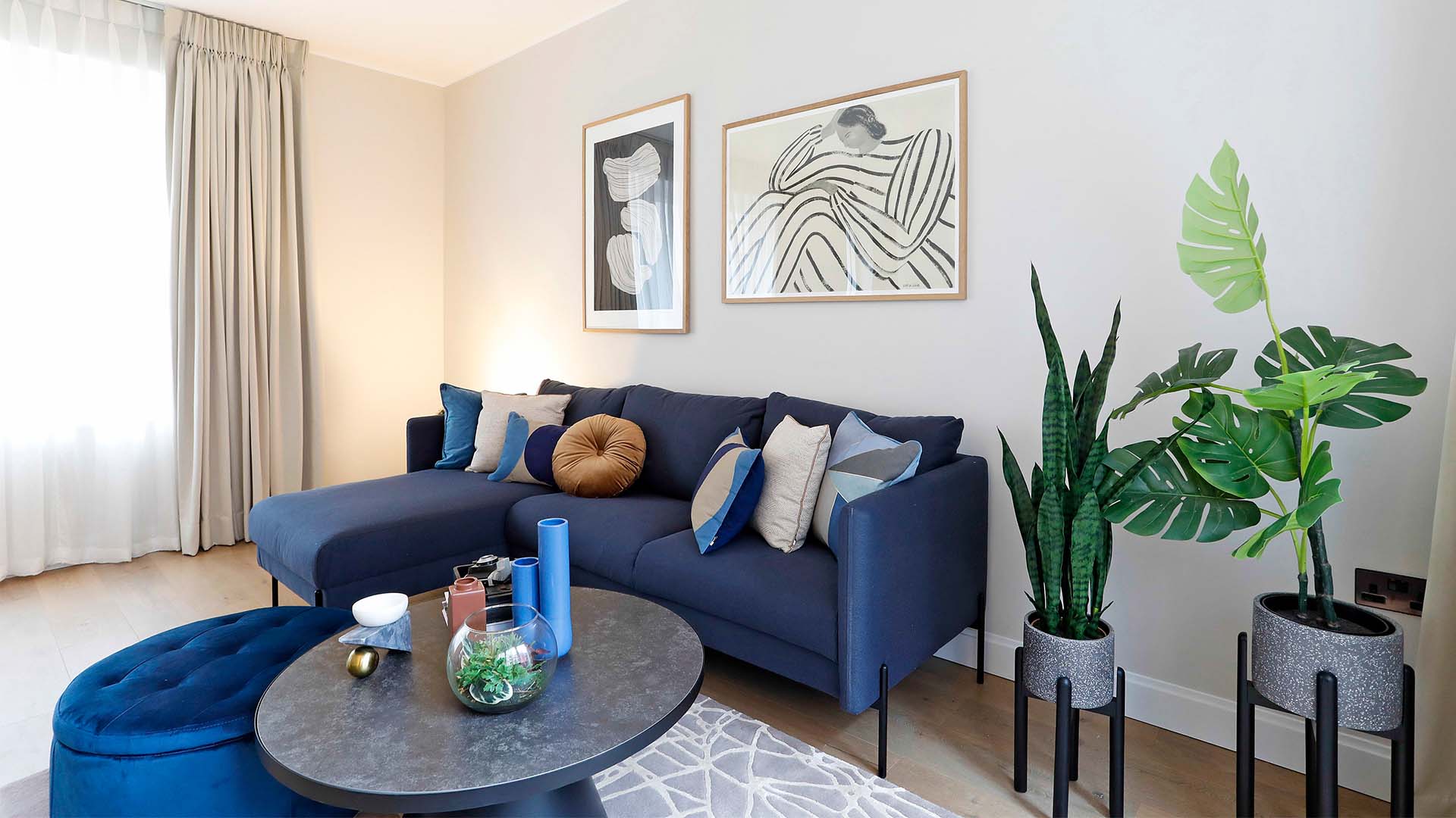 Modern living room with blue L-shaped sofa and glass coffee table