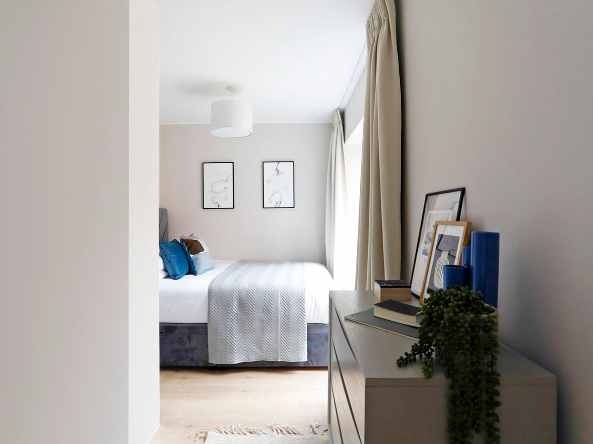 bedroom-showing-a-bed-and-dresser-with-simple-clean-styling