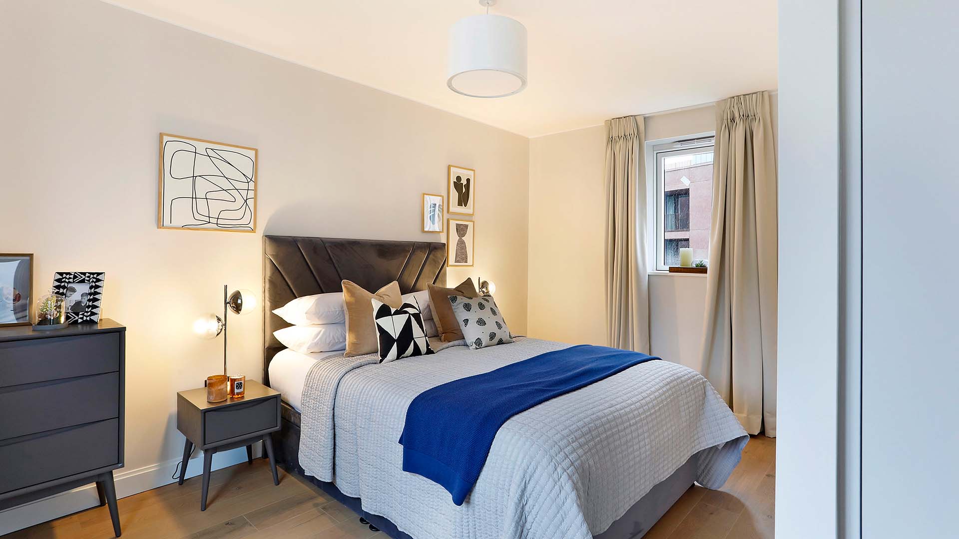 bedroom with a blue accent blanket, gray bedding, and simple decor