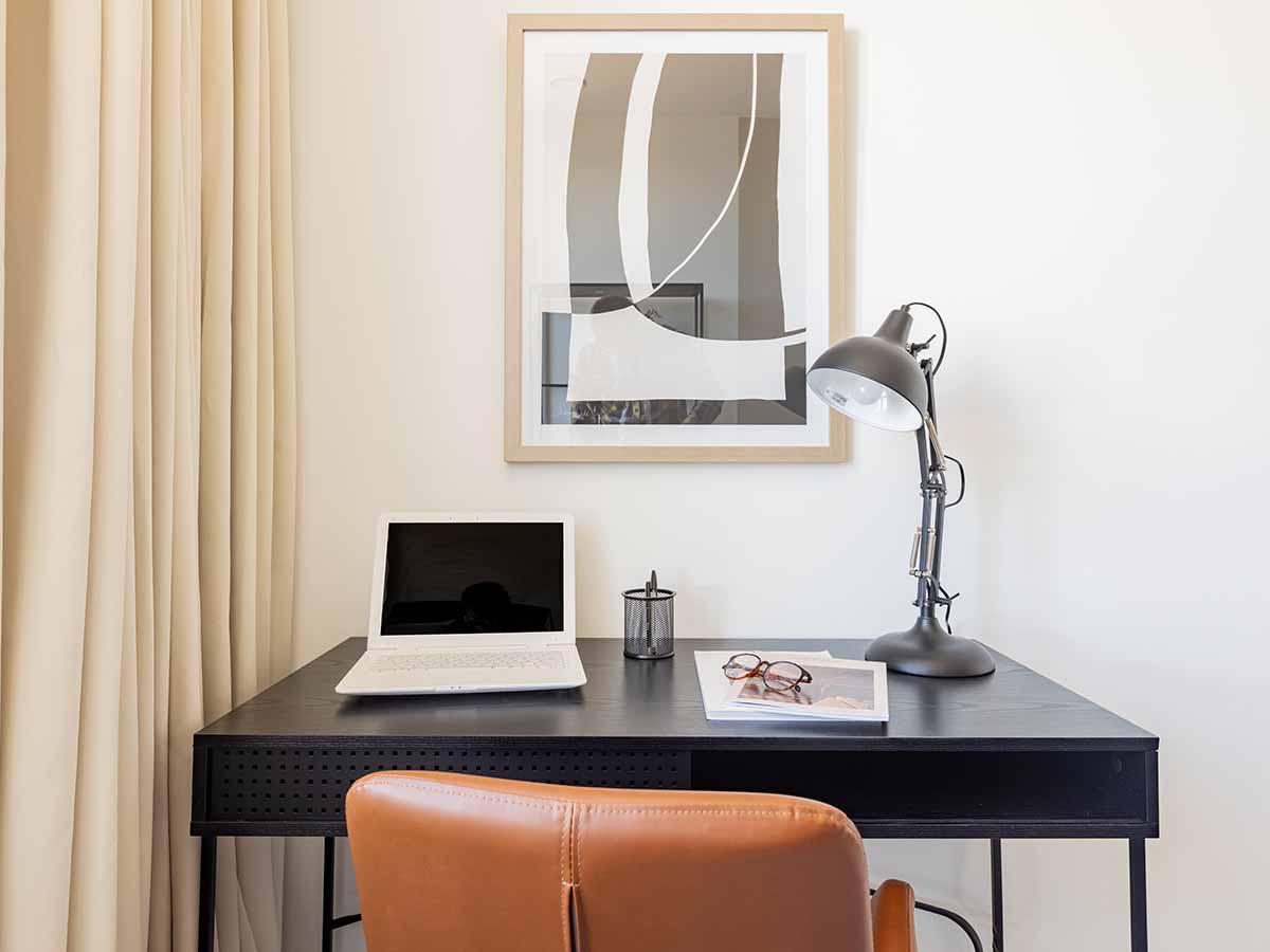 Modern home office desk with laptop and lamp