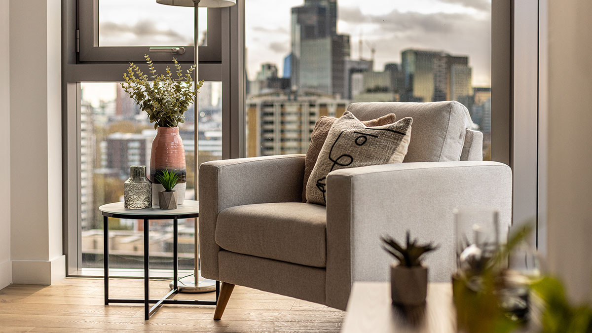Cozy armchair with city skyline view in a London flat, illustrating comfortable and appealing design for rental properties