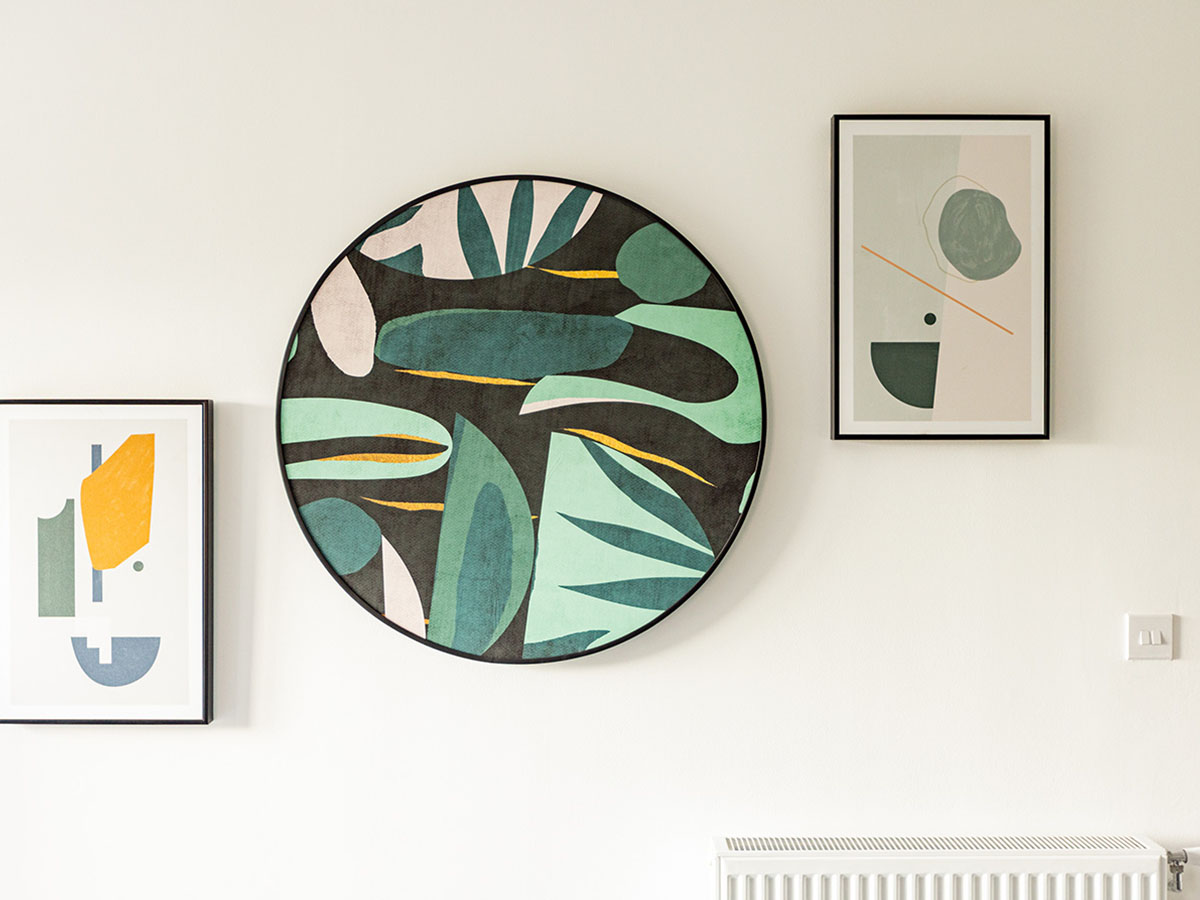 Close-up of modern abstract wall art, including a round piece, professionally styled in a London flat, showcasing attention to detail in furnishing packages