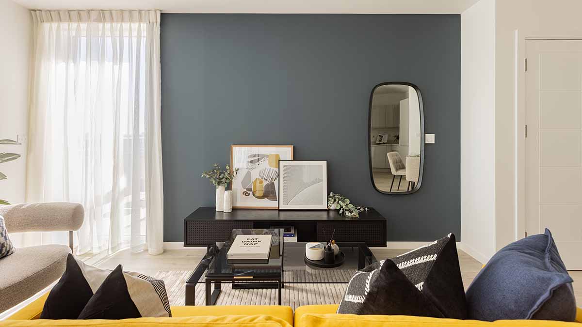 Contemporary London flat lounge with a chic blue feature wall, stylish mirror, and elegant furnishings, enhancing property appeal for sale.