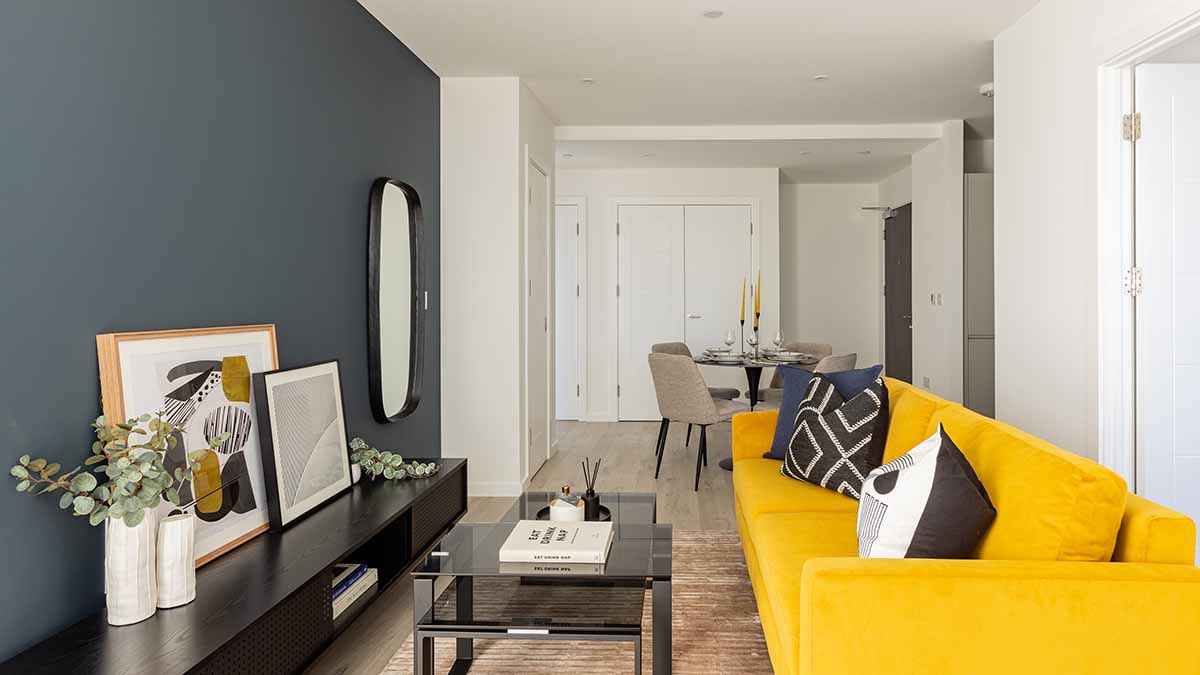 Vibrant open-plan living and dining area in a London flat with a striking yellow sofa, demonstrating an InStyle Direct transformation