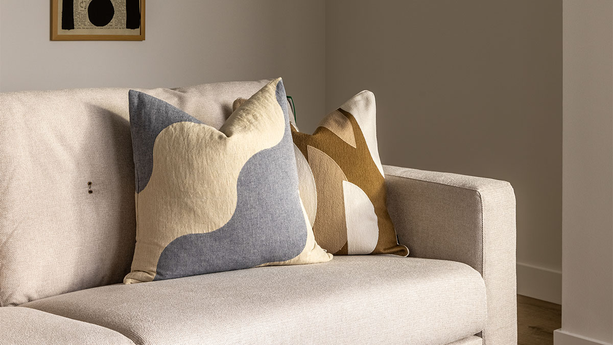 Close-up of designer cushions on a modern sofa in a London flat, highlighting attention to detail in professional interior furnishing