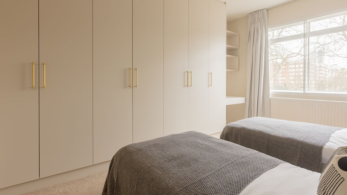 Refurbished bedroom with twin beds and custom wardrobes in SW7 flat