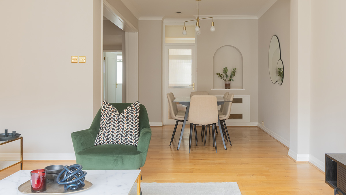 Refurbished dining area in SW7 flat with niche shelf, brass lighting, and neutral tones