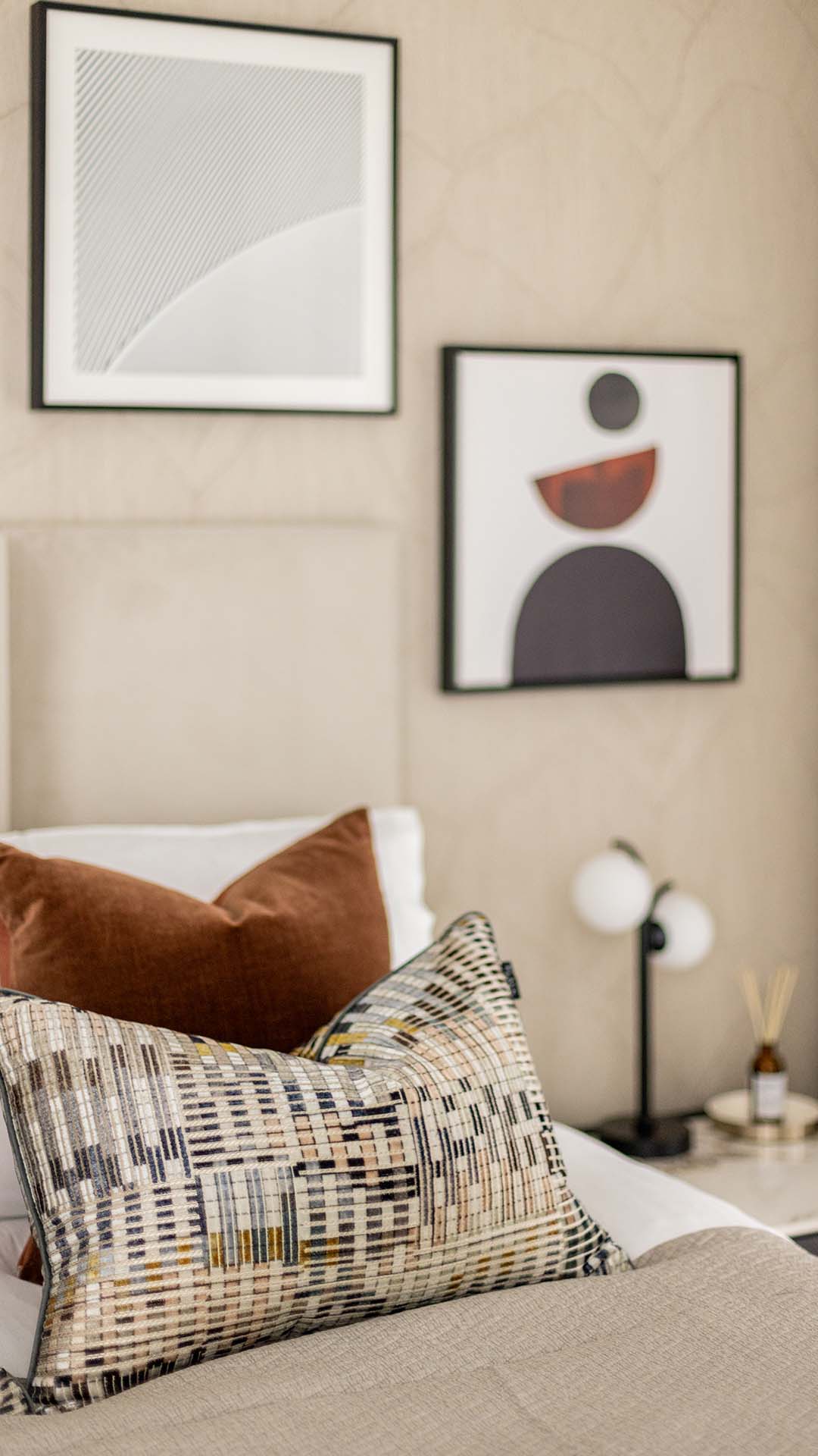 Close-up of stylish pillows and abstract art in a bedroom of a Kings Tower Chelsea London flat