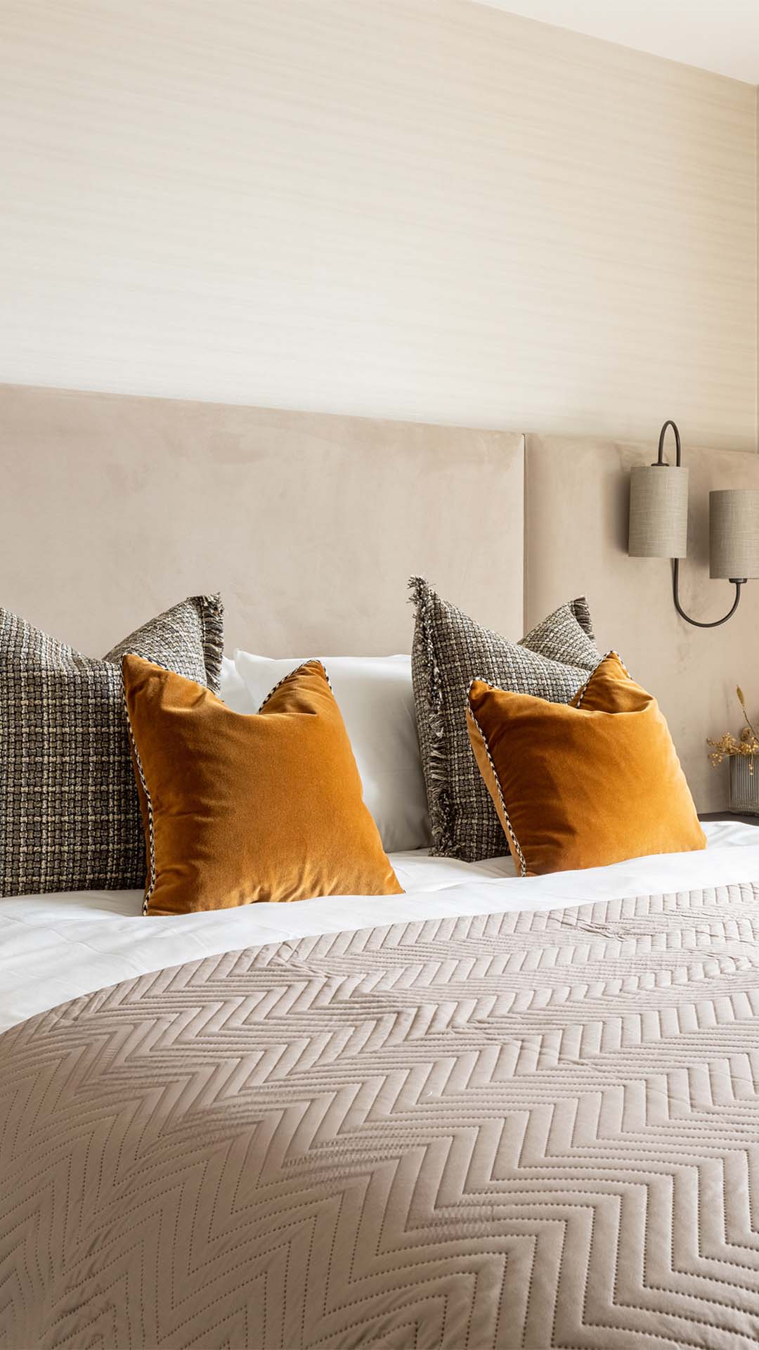 Close-up of luxurious pillows in varying textures and colors on a bed in a Kings Tower Chelsea London flat