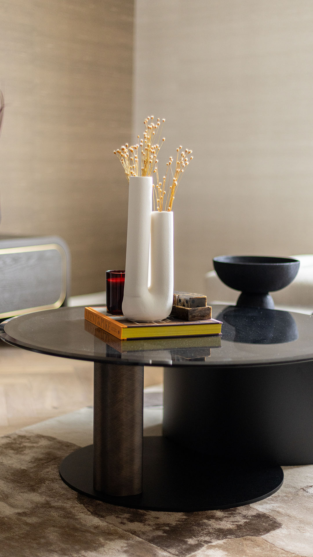 Stylish white vases with dried flowers and a red candle on a coffee table in a Kings Tower Chelsea London flat