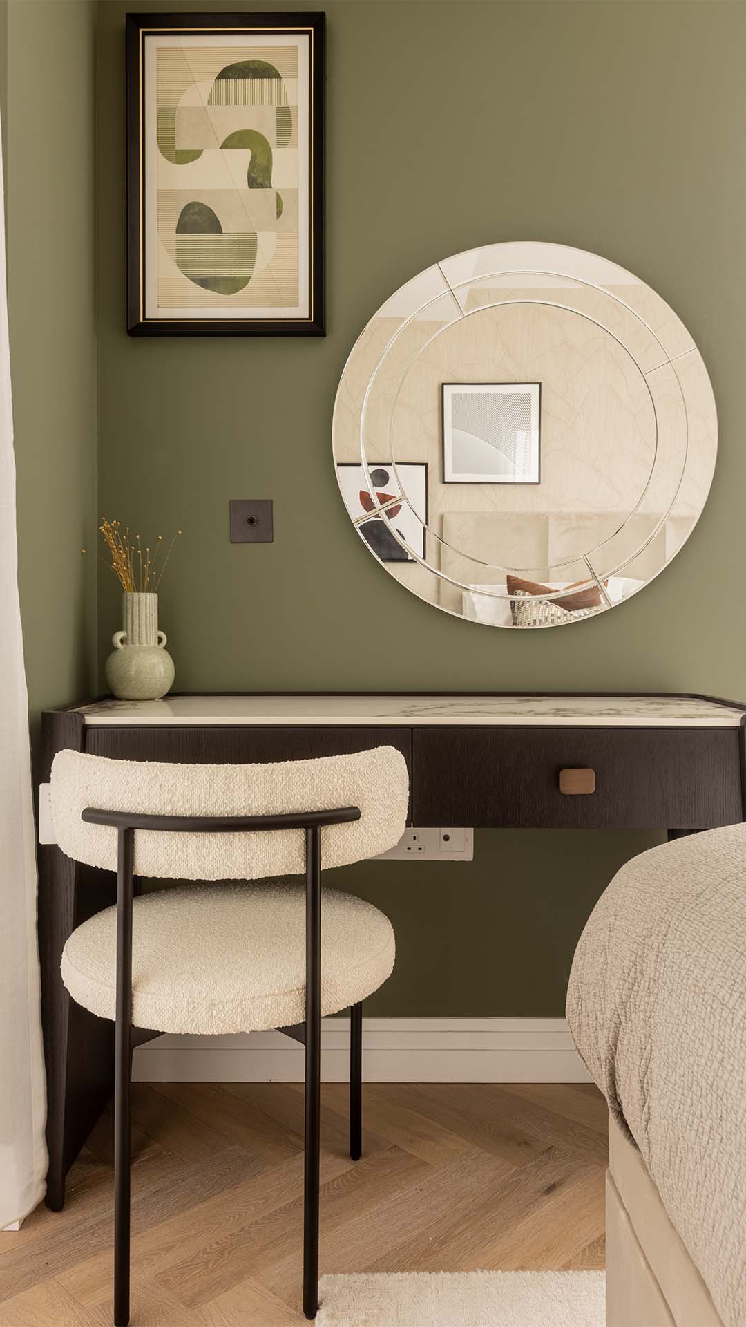 Elegant bedroom vanity area with a round mirror and modern chair in a Kings Tower Chelsea London flat