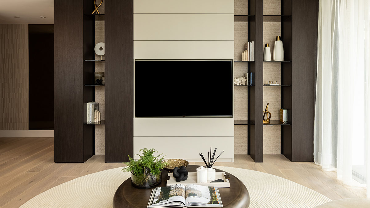 Modern living room featuring a sleek entertainment unit with integrated shelving in a London flat, showcasing functional and stylish furnishing solutions