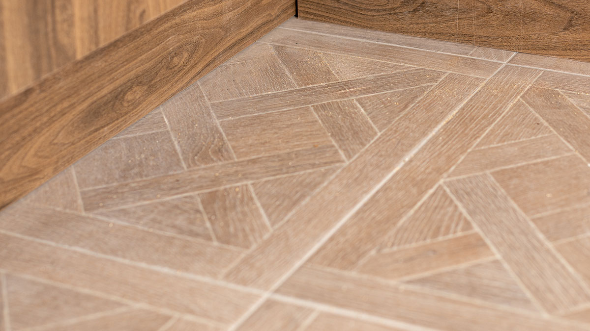 Close-up of geometrically patterned floor tiles in a London property, seamlessly meeting wooden baseboards, highlighting sophisticated flooring choices