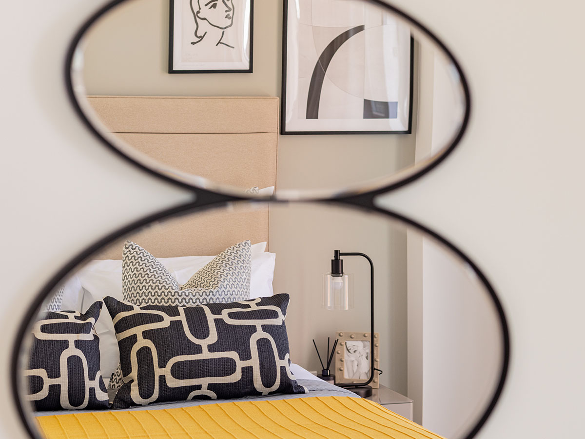 Detail shot of a bedside table and mirror, showing the meticulous styling of the bedroom furnishing package at Meridian One