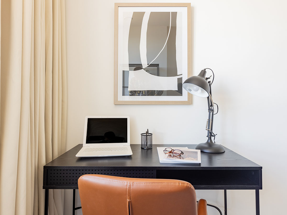 Close-up of a stylish desk setup in a London flat with a laptop and lamp, a popular feature for modern tenants