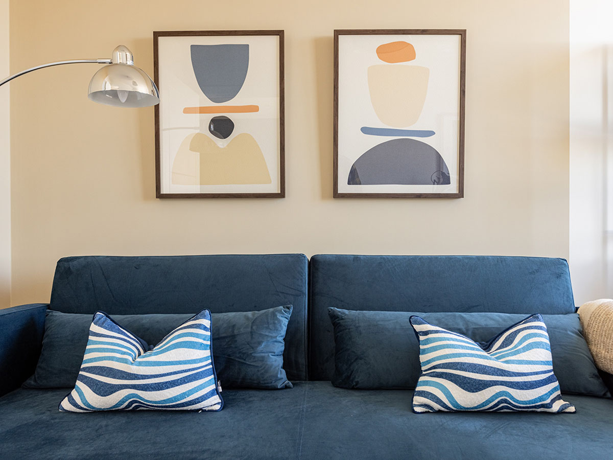 Professionally furnished blue sofa with art prints on the wall, showcasing an InStyle Direct transformation for a London flat
