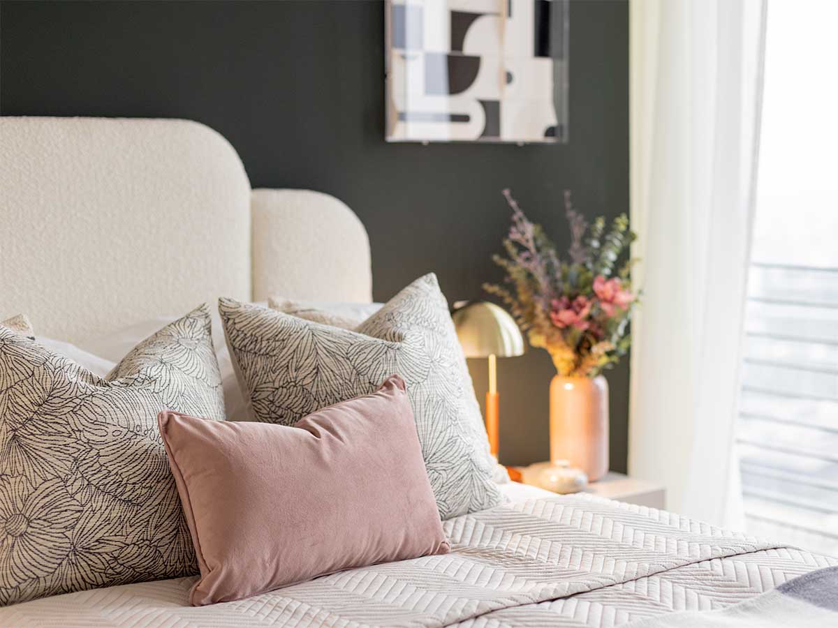 Detail of a luxurious bed with a pink velvet pillow in an Instyle Direct show home