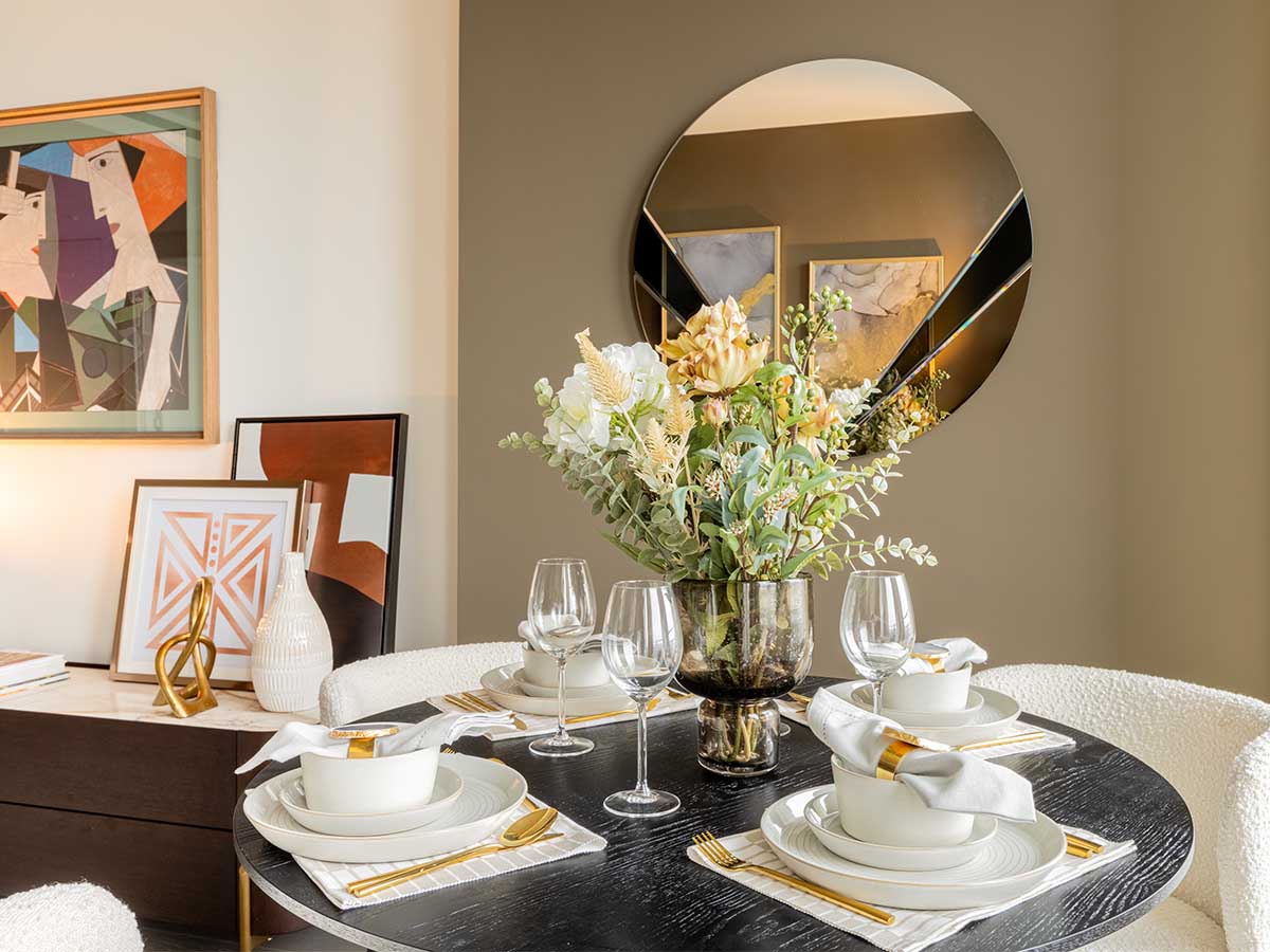 Elegant dining table setting with gold accents staged for a show apartment