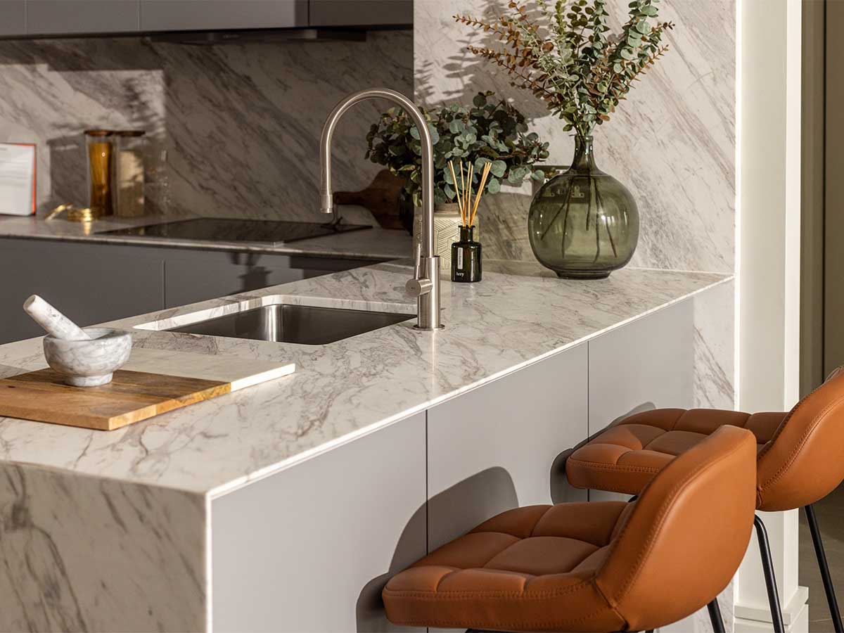 Modern kitchen with marble island and leather bar stools by Instyle Direct