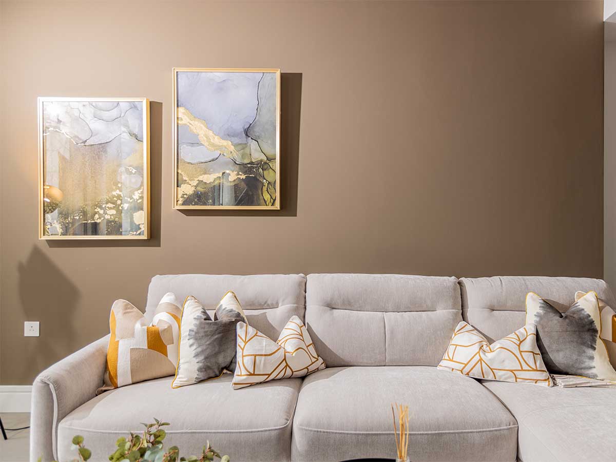Living room with a grey modular sofa and abstract art by Instyle Direct