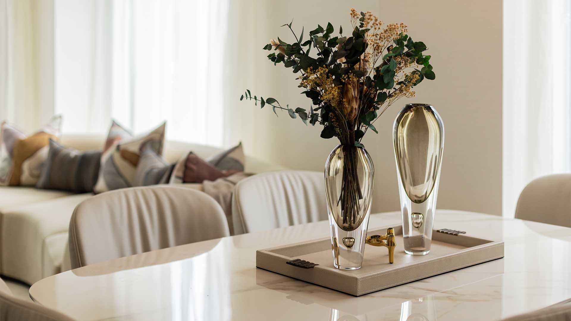 Staged dining table with elegant vases and tray in a London flat, showcasing professional interior design for rental appeal