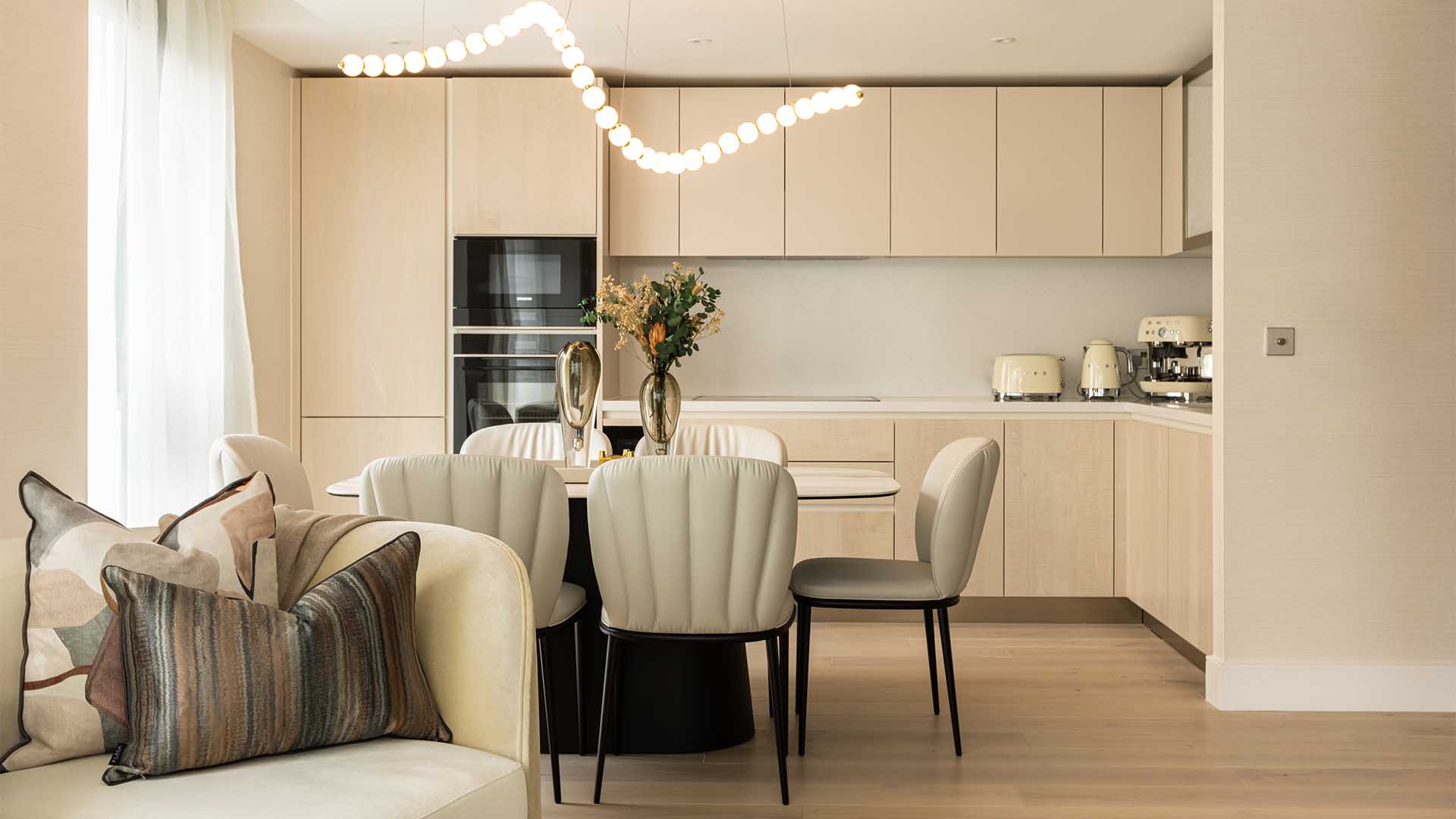 A sleek, modern kitchen and dining area in a London flat, professionally furnished to attract premium tenants